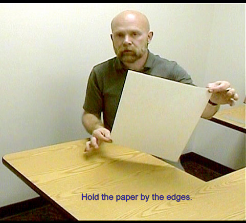 holding the drawing paper by the edges